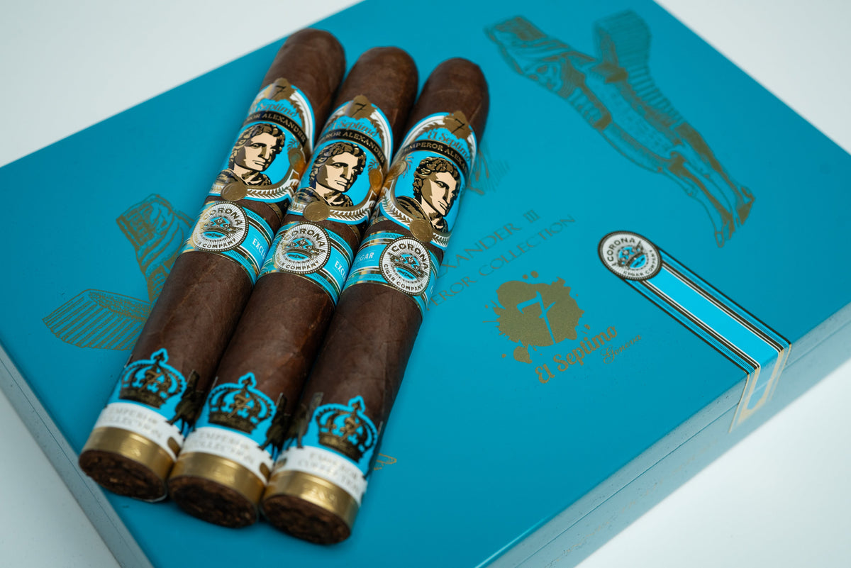 three premium cigars with a blue, gold and black label with an image of emperor alexander on a light blue and gold premium cigar box